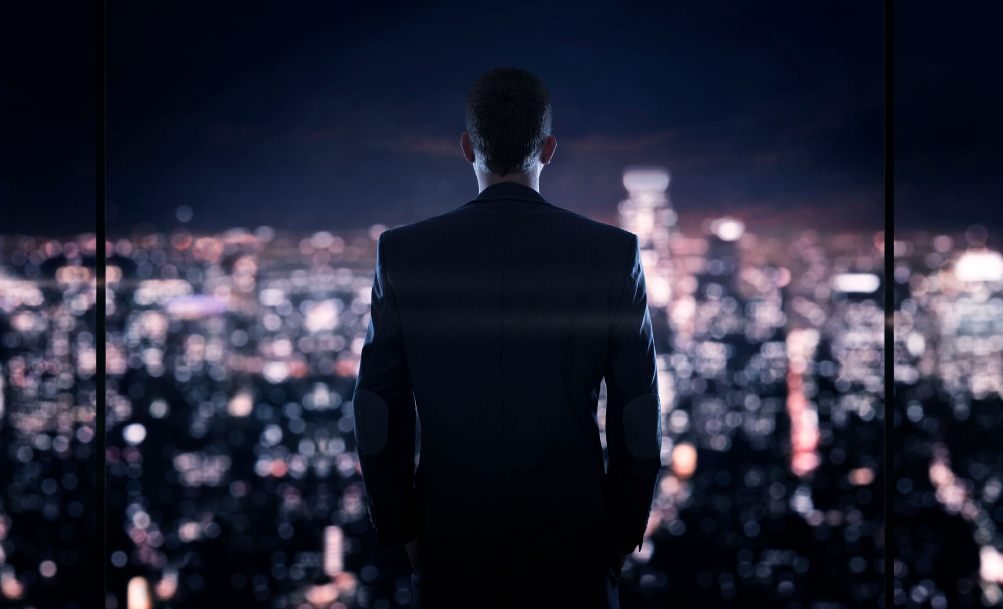 Businessman looking at the the city at night