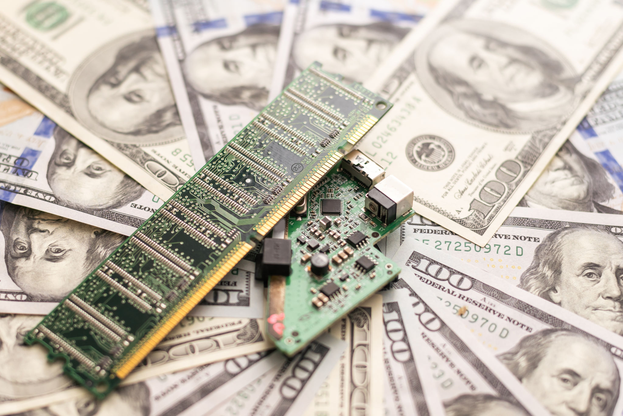 Computer board and one hundred dollars bill closeup.